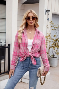 Detailed view of pink plaid long-sleeve shirt tied at the waist for a casual look