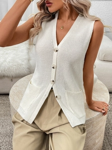 Close-up of cream crochet vest sweater featuring a V-neck and tortoiseshell buttons