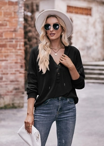 Outdoor-Streetstyle-Foto von schwarzem langärmeligem Henley-Hoodie mit geknöpftem V-Ausschnitt