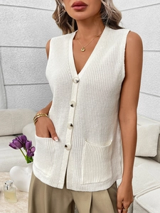 Close-up of white chunky knit vest with V-neck button design and front patch pockets