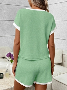 Detail of mint green ribbed loungewear set featuring white contrast binding from the back