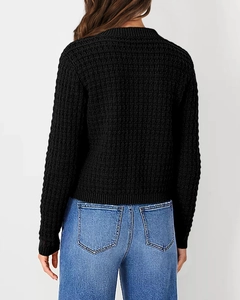 Detail view of the back of a black knit cardigan with textured stitching and ribbed hem