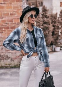 Detail of blue and white plaid long sleeve flannel shirt with chest pockets and collar