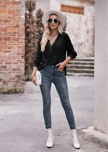 Outdoor-Streetstyle eines schwarzen V-Ausschnitt Kapuzenpullovers mit Skinny Jeans