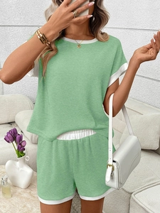 Detail showing waffle texture and white contrast trim on light green casual summer set