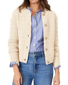 Detailed macro view of beige knit cardigan showing thick cube texture and buttoned front