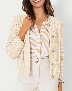 Detailed view of cream knit cardigan featuring vertical ribbed texture and dark buttons