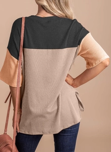Back view of a color block knit top showing high-quality vertical ribbing and side slit