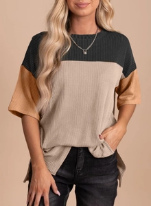 Detail of color-block ribbed knit top featuring side slit and premium textured fabric