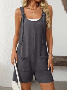 Dettaglio della tutina in maglia a righe grigio scuro con spalline annodate e grandi tasche