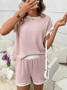 Detail of pink ribbed knit texture and white contrast trim on short sleeve summer set