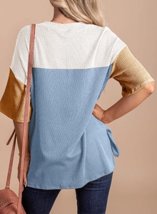 Detail of the back profile showing tricolor striped rib-knit fabric and relaxed fit cut