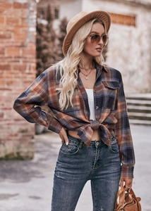 Close-up of oversize orange and navy plaid flannel shirt with front button pocket