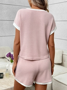 Close-up of pink knit two-piece set with white contrast trim on the back view