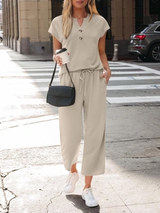 Detailed texture of beige knit summer set featuring a short sleeve top and wide leg pants