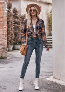 Detail of oversized orange plaid flannel shirt with drop shoulders and chest pockets