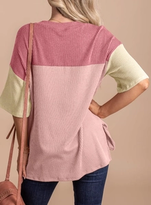 Close-up of color-block rib-knit short sleeve tee showing side slit and back texture