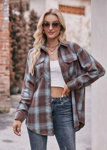Detail of oversized plaid flannel shirt with flap pockets and tortoiseshell buttons