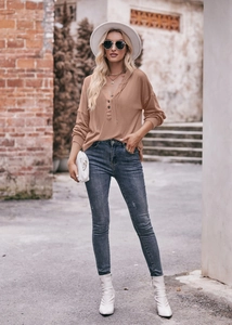 Outdoor-Streetshot eines kamelfarbenen Kapuzenpullovers und blauer Slim-Jeans