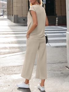 Detail of oat-colored two-piece set featuring short-sleeve top and wide-leg trousers