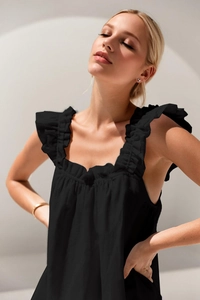 Detail of black sleeveless top featuring ruffled shoulder straps and square neckline