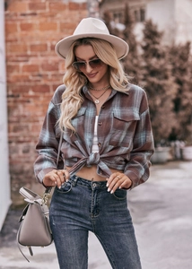 Detail of oversized plaid shirt with buttoned chest pockets and a classic turndown collar
