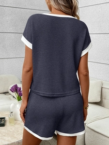 Detail of waffle knit fabric with white contrast piping on dark blue lounge set