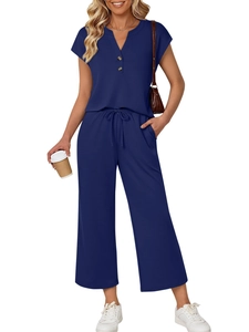 Detail view of navy blue short sleeve top featuring V-neckline and decorative amber buttons