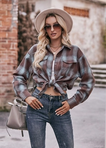 Detail of oversized plaid shirt with front pocket and stylish front tie knot design