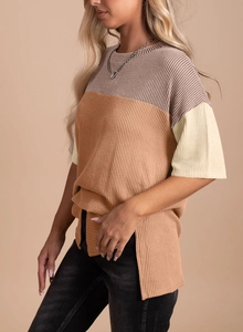 Detail view of tri-color patchwork ribbed knit T-shirt with split hem and soft texture