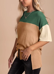 Close-up of color-block knit T-shirt featuring vertical ribbed texture and side slits
