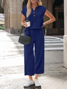 Detail of dark blue short sleeve v-neck top with wood texture buttons and drawstring waist