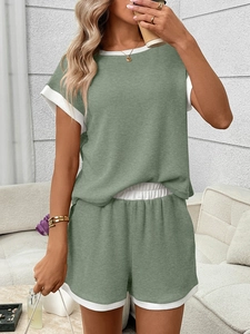 Close-up of light green waffle knit fabric with white contrast piping on the sleeve