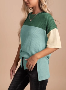 Detail view of the ribbed texture, color-block stitching and side slits on the t-shirt