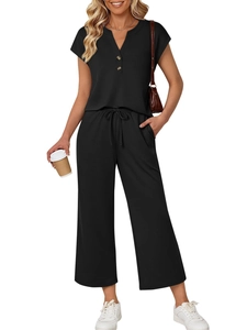 Detail of black lounge set showing V-neck top with buttons and drawstring waist pants