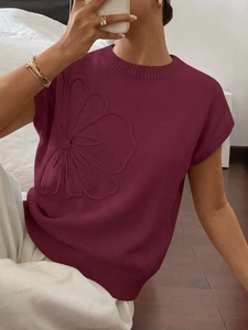 Dettaglio della maglia bordeaux con fiori a rilievo 3D e bordi rifiniti a costine