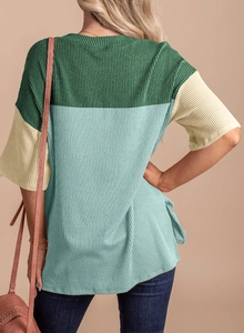 Detail of color-block knit top back view with ribbed texture and side slit design