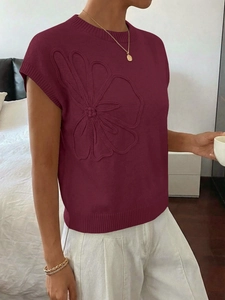 Dettaglio del gilet in maglia bordeaux con trama floreale 3D e bordi a costine fini