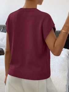 Dettaglio dell'orlo e del colletto a coste di questo gilet in maglia bordeaux rifinito