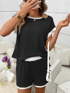 Detailed view of women's two-piece set with ribbed fabric texture and white contrast piping