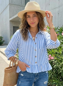 Detail of blue striped shirt showing peplum hem and rustic wood buttons in daylight