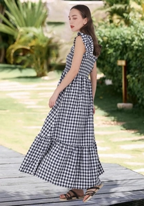 Detail of a tiered black and white gingham maxi dress with ruffled sleeveless shoulders