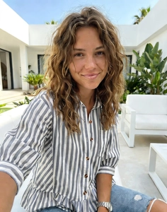 Detail of blue striped women's shirt with brown buttons and stylish puff sleeves