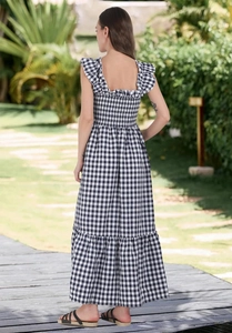 Detailed back view of smocked gingham maxi dress with ruffle straps in outdoor garden setting