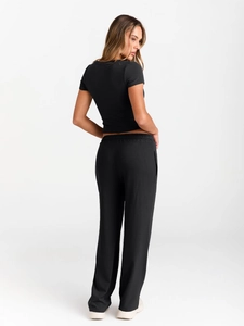 Side view of soft black short sleeve crop top and high waist wide leg pants set for women