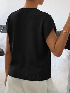 Dettaglio dell'orlo a costine e vista posteriore di un gilet in maglia nera da donna
