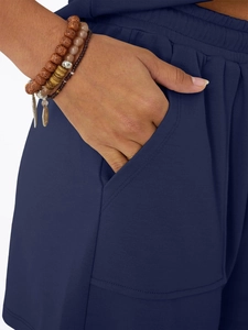 Detail shot of navy blue knit shorts featuring elastic waist and functional side pockets
