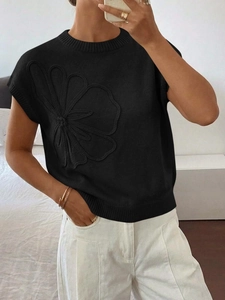Dettaglio del maglione in maglia nera a maniche corte con motivo floreale 3D