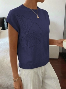 Dettaglio del top in maglia blu scuro con ricamo floreale 3D e bordi a costine