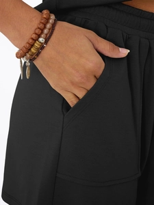 Detail of black knitted fabric shorts featuring slanted pockets and premium double stitching